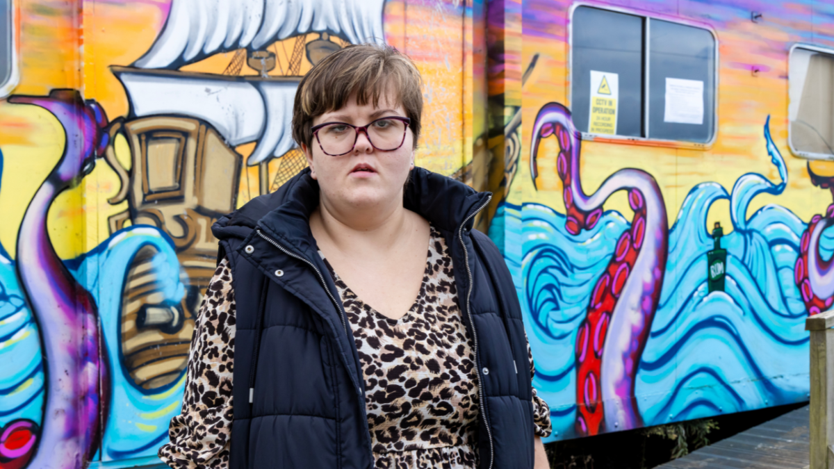 Melanie in front of a ocean themed painted wall