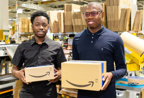 Supported internship graduates Timi and Hayden at work in Amazon's Tilbury Fulfilment Centre.