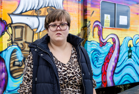 Melanie in front of a ocean themed painted wall