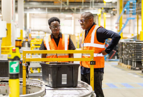 A young male intern at Amazon working alongside his job coach.