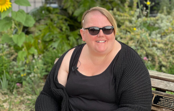 Lady sitting on a bench with a hearing aid