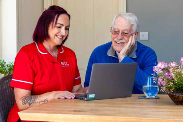 A man and a woman looking at a laptop