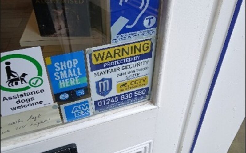 Photo of the shop's front door to show that there is a sticker detailing that shop has an Induction Loop and that assistance dogs are welcome.