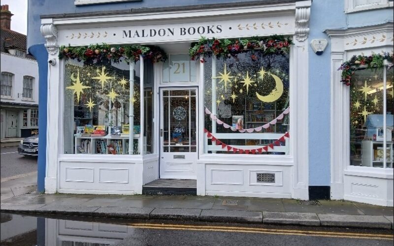 Exterior photo of the shop with blue colour contrasts for the visually impaired around the doors. This is a wide shot taken from the other side of the street.