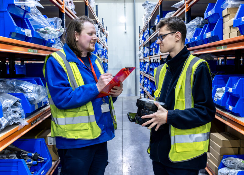 Two men talking to each other in a storage room