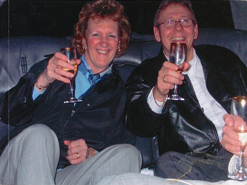 Man and woman celebrating, raising glasses of champagne.