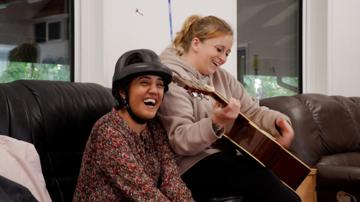 Chloe playing guitar and putting on the show for ECL customers