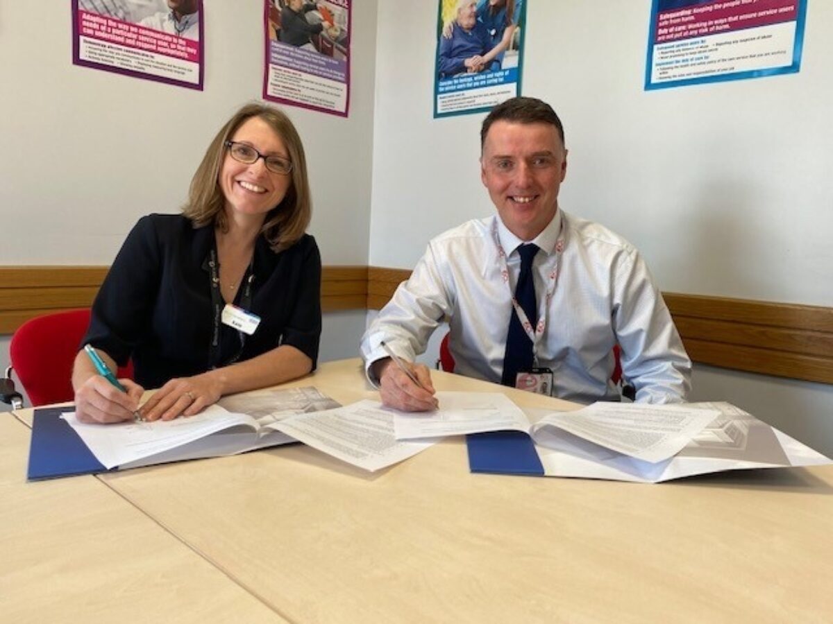 Two people working through documents on a desk