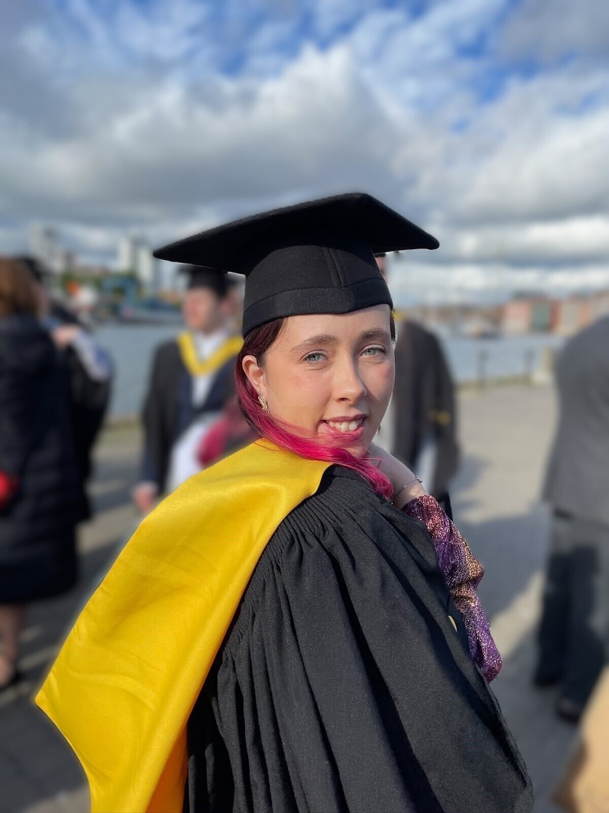 Young woman in cap and gown at her university graduation