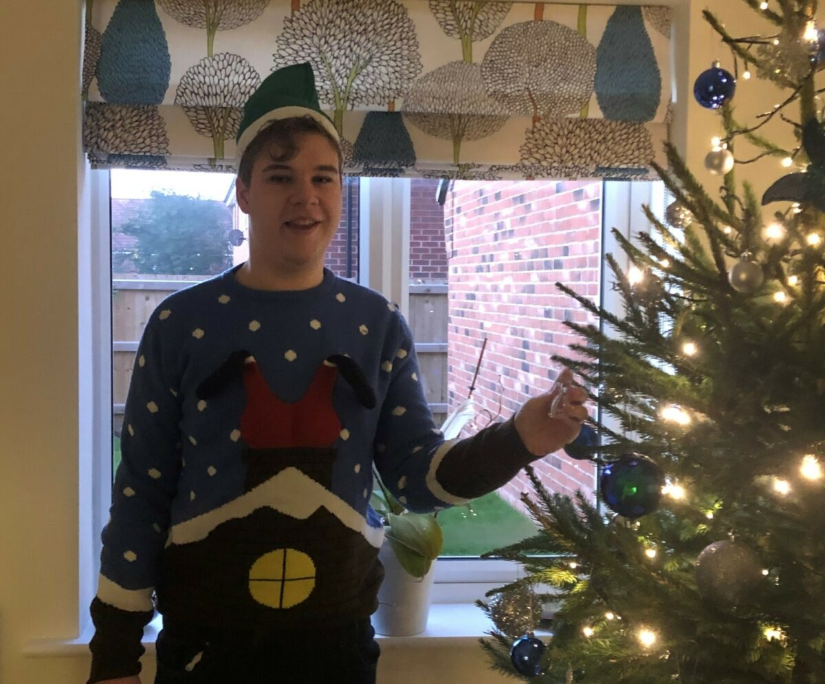 Lynden is his Christmas jumper decorating his family home's Christmas tree.