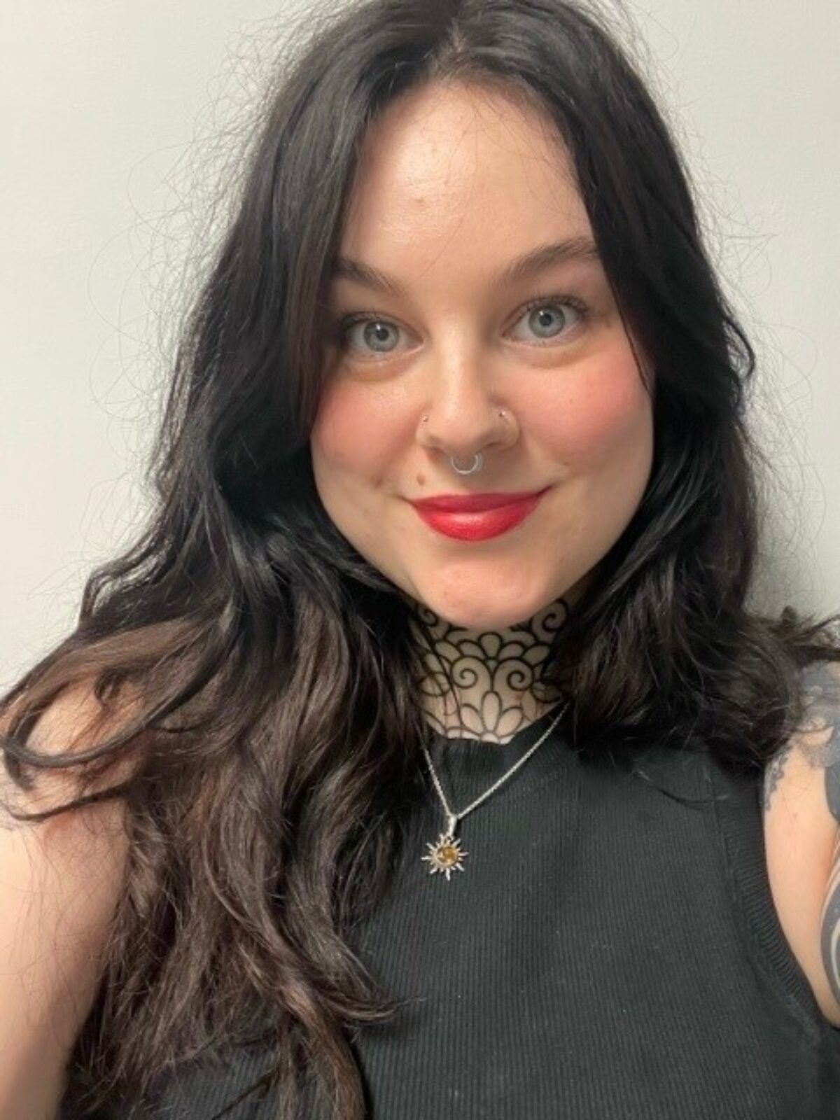 A woman with dark brown hair looking at the camera