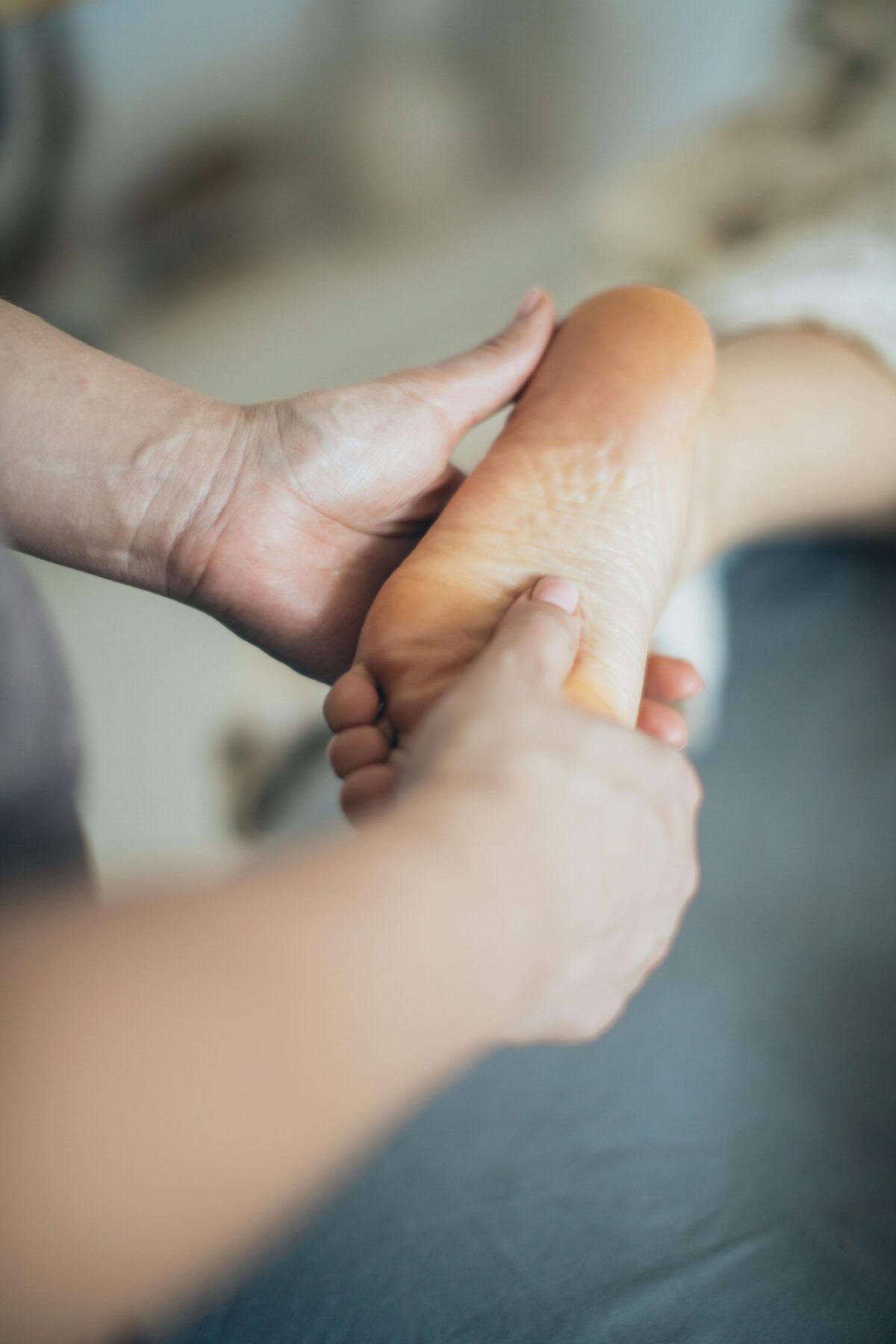 A close up picture of a hand doing physio exercises on a foot.