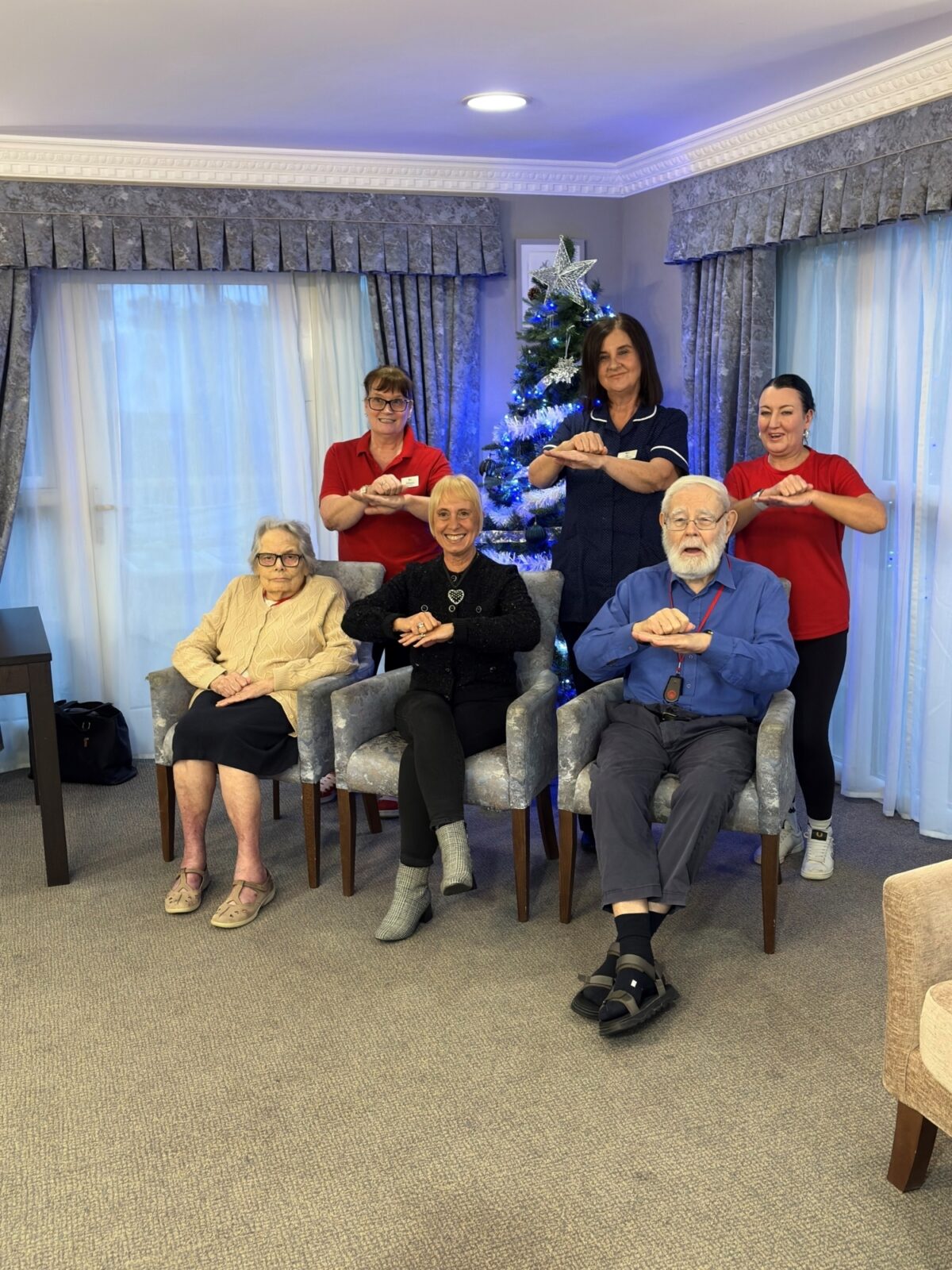 Cherry Wood Grange Care home staff and residents gathered by the Christmas tree.