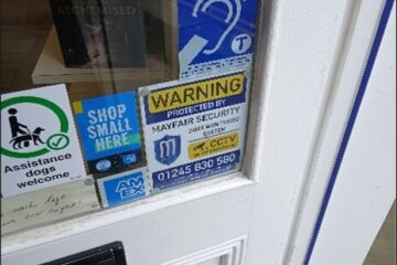 Photo of the shop's front door to show that there is a sticker detailing that shop has an  Induction Loop and that assistance dogs are welcome.