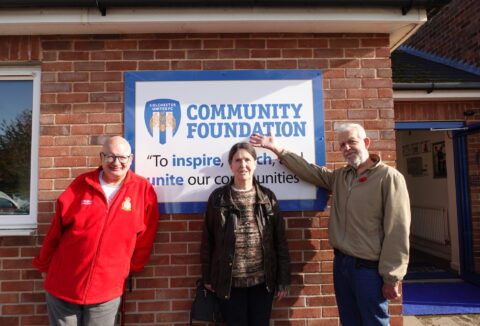 Three ECL customers standing in front of Colchester Community Foundation signage smiling