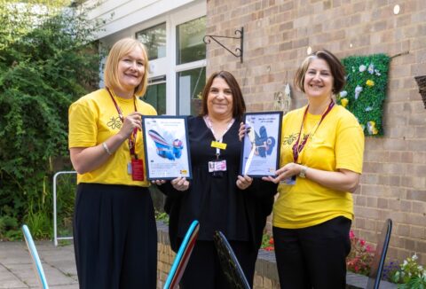 Farleigh staff and Highfields Manager with bee sculptures and certificate of participation.