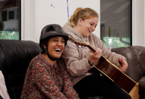 Chloe playing guitar and putting on the show for ECL customers