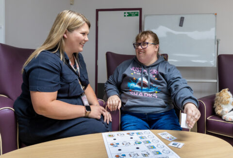 Lady with autism being supported to use a choice board
