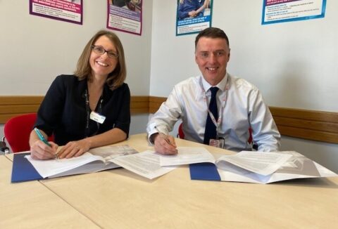 Two people working through documents on a desk