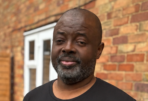 Man standing outside a house.