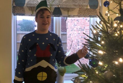 Lynden is his Christmas jumper decorating his family home's Christmas tree.