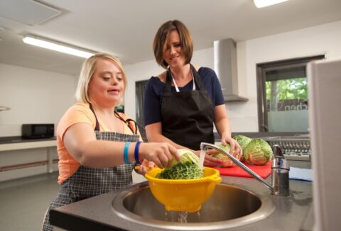 Carer helping customer prepare some food
