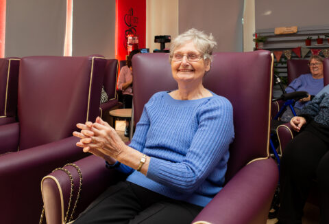 An elderly woman sitting down