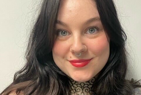 A woman with dark brown hair looking at the camera