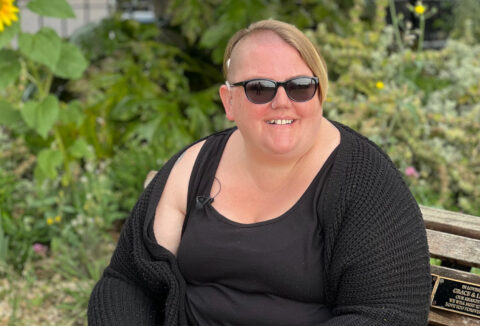 Lady sitting on a bench with a hearing aid