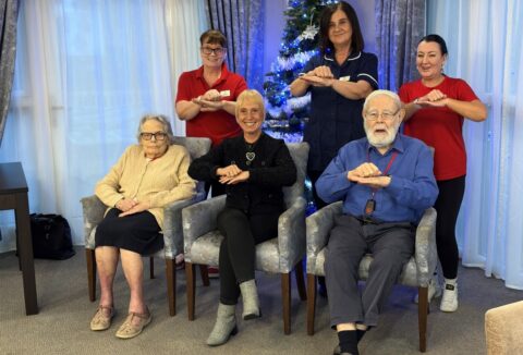 Cherry Wood Grange Care home staff and residents gathered by the Christmas tree.